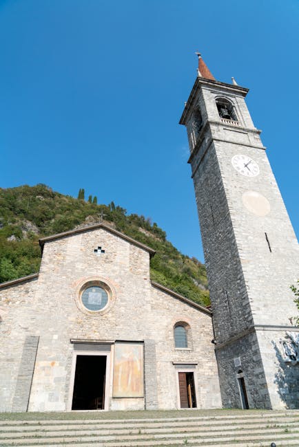 Stone church and tall bell tower against blue sky in Praiano, Côte amalfitaine