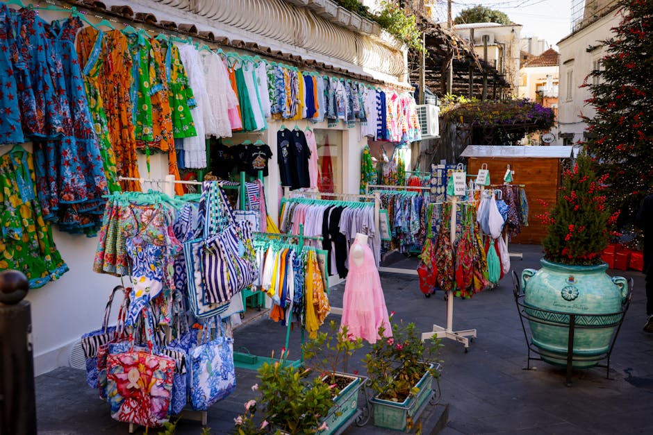 Étals colorés de vêtements et sacs artisanaux dans une ruelle de la Côte amalfitaine