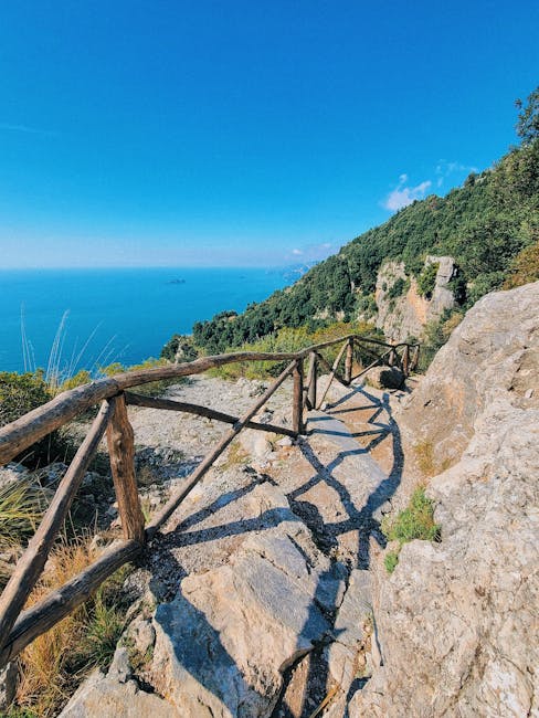 Steiniger Küstenpfad mit Holzgeländer über dem Meer an der Côte amalfitaine