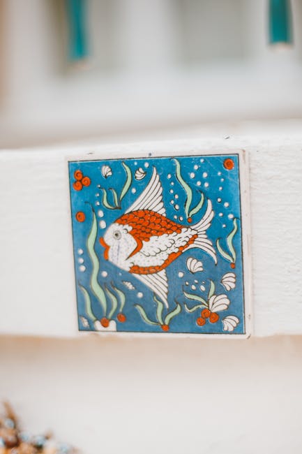 Keramikfliese mit orangefarbenem Fischmotiv an weißer Wand an der Côte amalfitaine