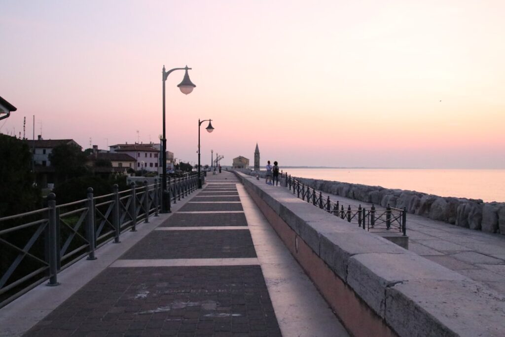 Leere Promenade mit Laternen bei Sonnenuntergang an der Côte amalfitaine.