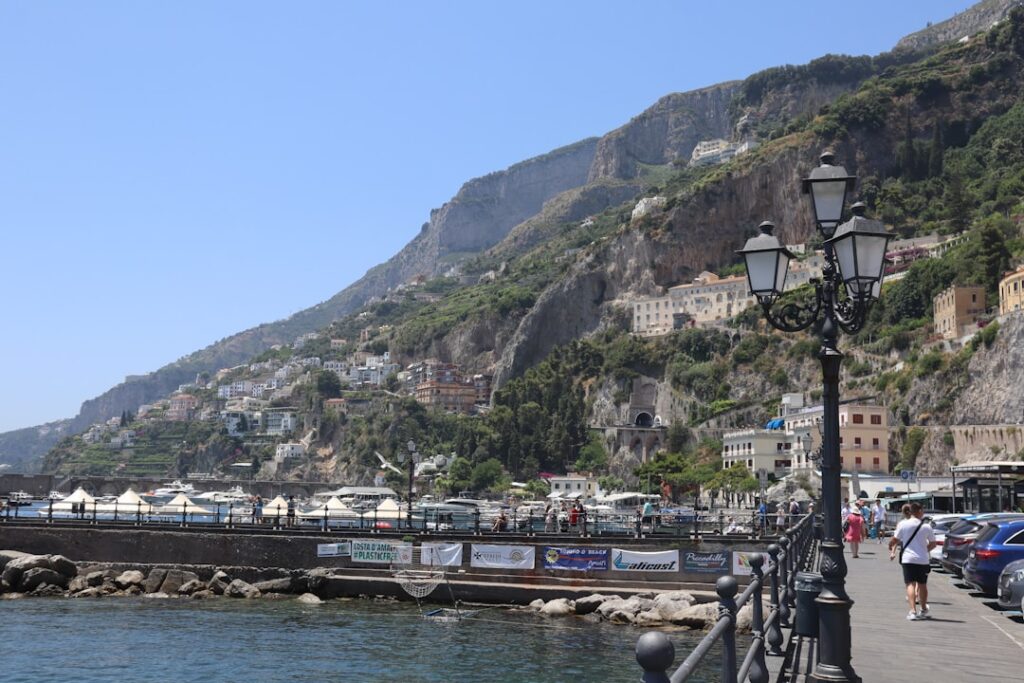 Promenade maritime avec lampadaire et falaises typiques de la Côte amalfitaine