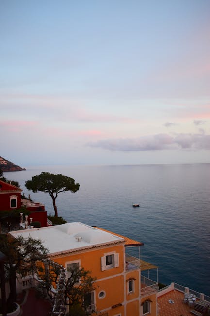 Terrazze e alberi davanti al mare calmo della Costiera Amalfitana all'alba