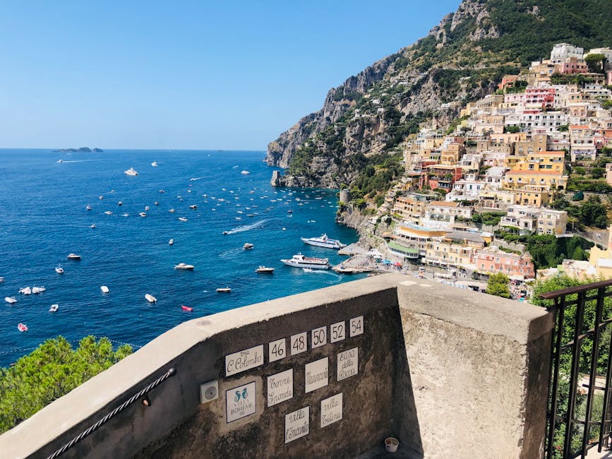 Stone terrace overlooking numerous boats and colorful Positano houses on the Amalfi Coast