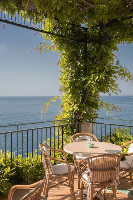 Wisteria-covered terrace with wicker chairs and uninterrupted sea view on the Amalfi Coast