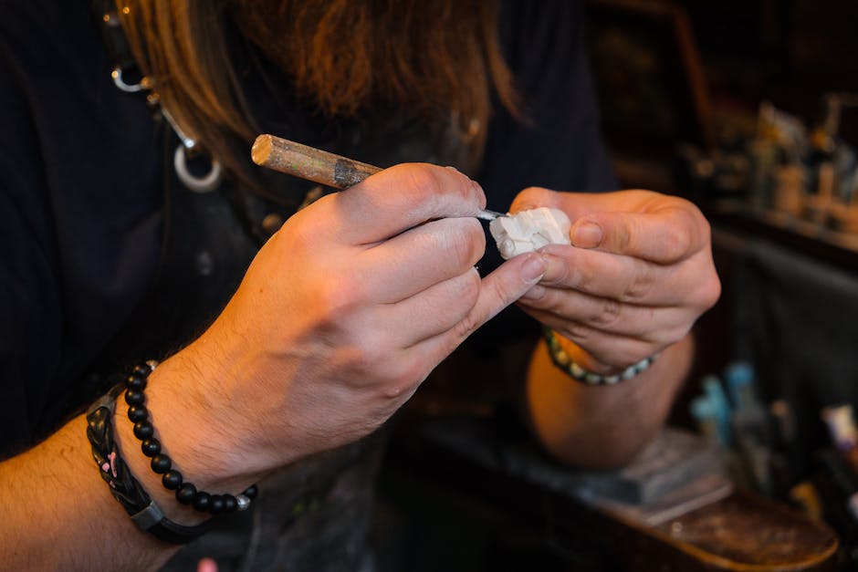 Mains d'artisan finissant une petite sculpture dans un atelier de la Côte amalfitaine