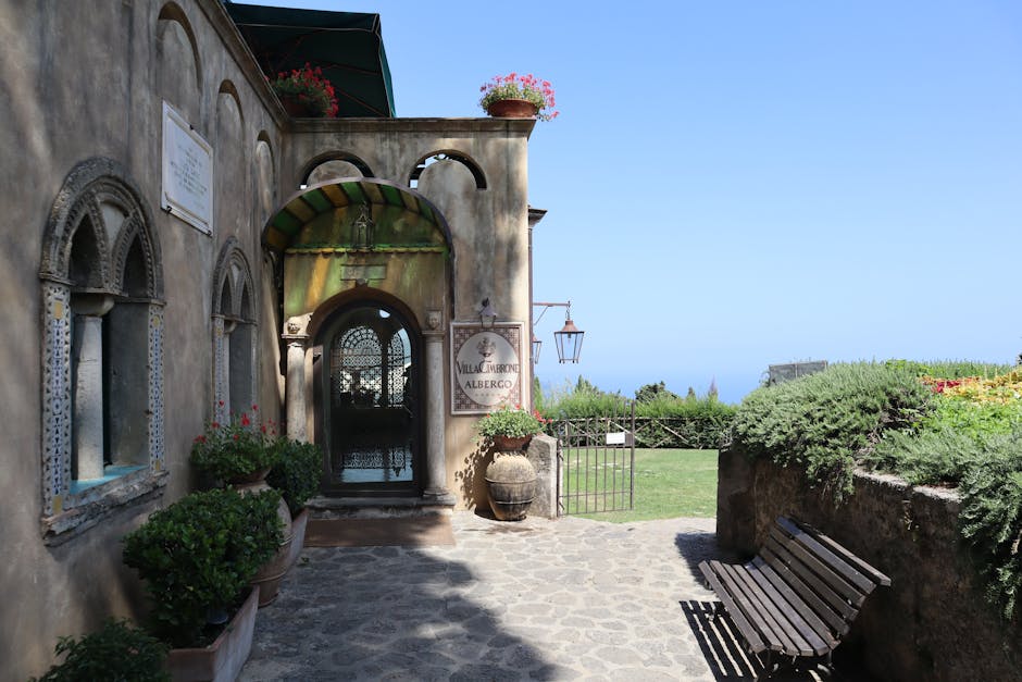 Toegangspoort van Villa Cimbrone met bloemen en zeezicht aan de Côte amalfitaine