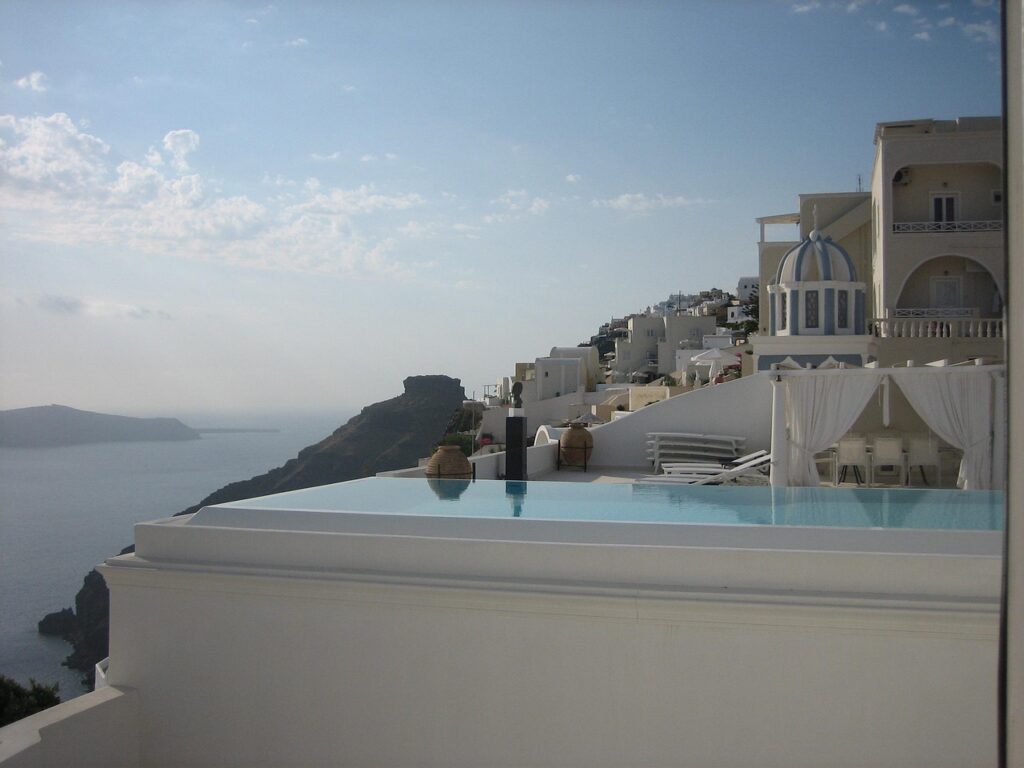 Infinity-Pool über weißem Gebäude mit Meerblick und felsiger Küste