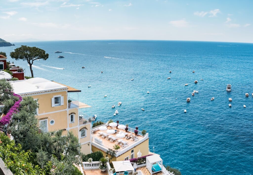 Terrazza con lettini e ombrelloni su scorcio della Costiera Amalfitana