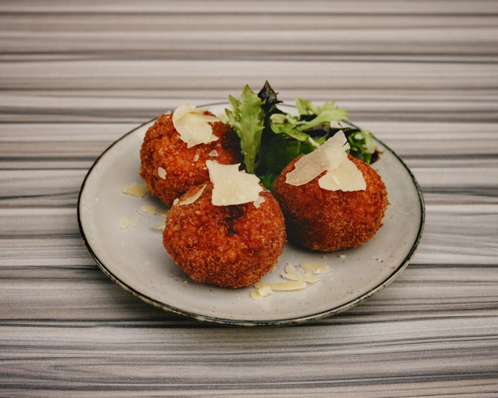 Cross-section of an arancini showing meat ragù and melting cheese