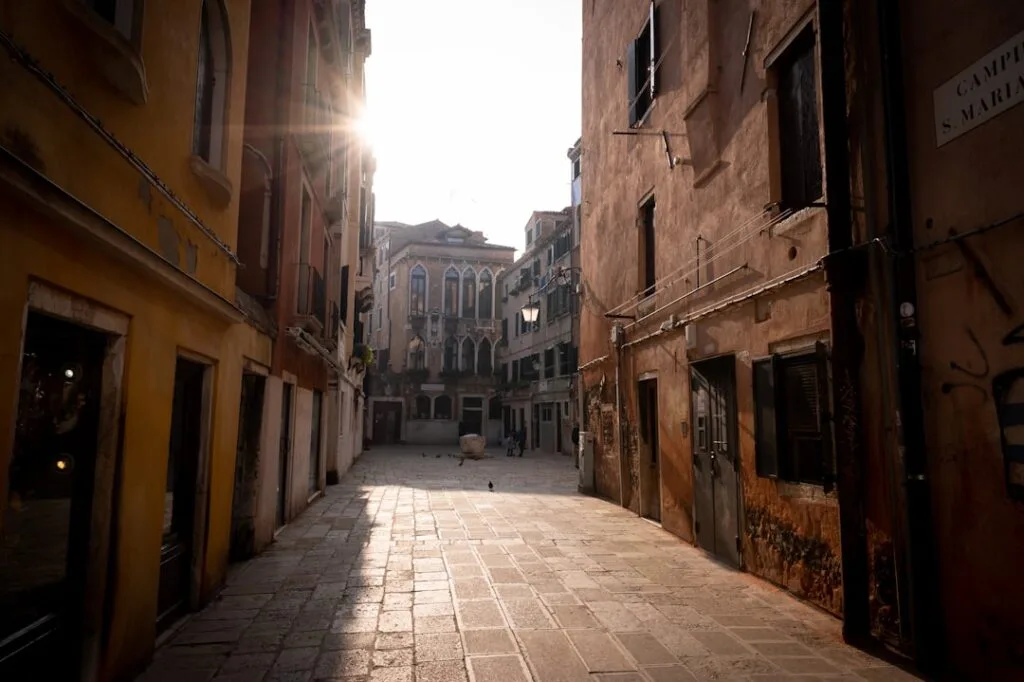 Rue pavée et façades anciennes baignées de soleil à Palermo
