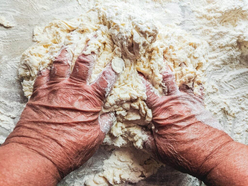 Hands kneading pasta dough close-up in Sicily