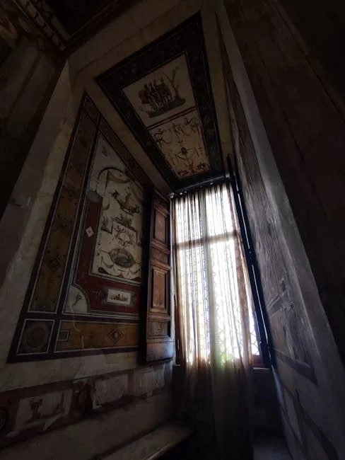 Fresques murales et fenêtre haute laissant filtrer la lumière dans un palais de Palermo