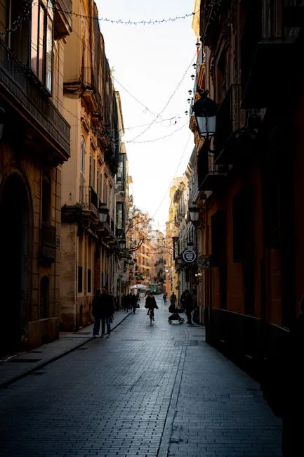 Rue étroite bordée de bâtiments historiques à Palermo, passants au loin