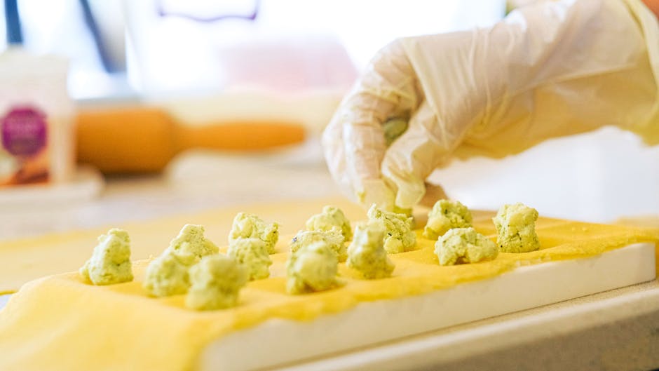 Hands shaping and rolling traditional ravioli