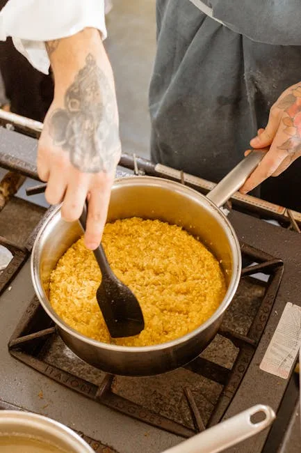 Mains tatouées remuant du risotto, atelier de cuisine à Palerme