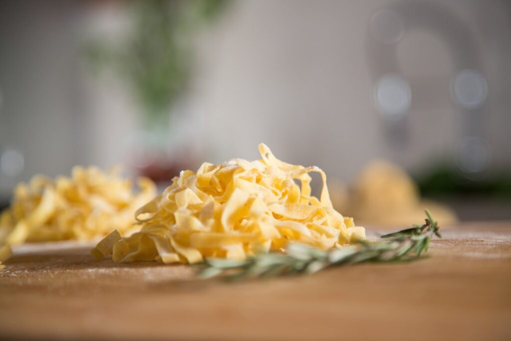 Wooden table with freshly made pasta