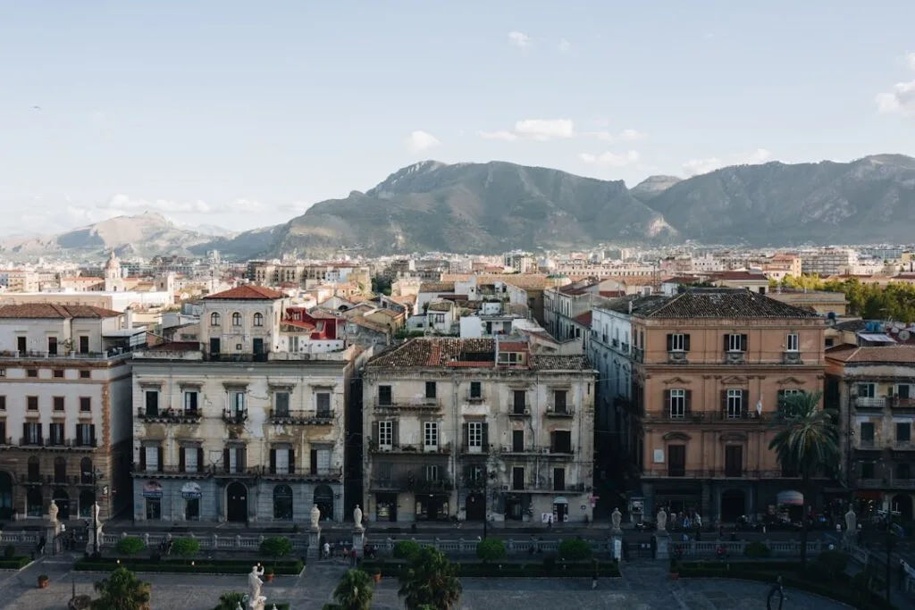 Façades baroques de Palermo avec montagnes au loin et toits anciens