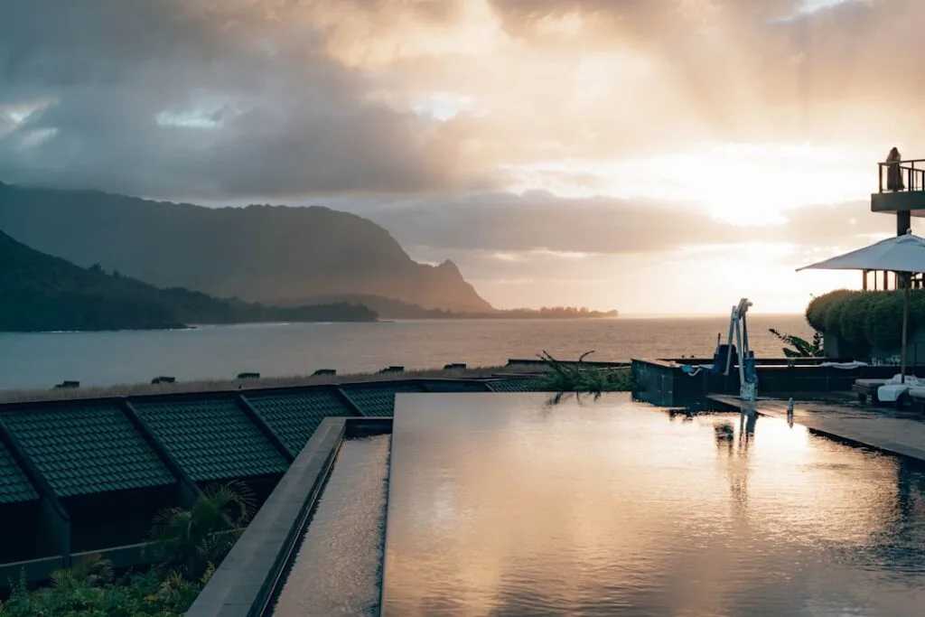 Piscine à débordement sur toit face à la mer et montagnes au coucher