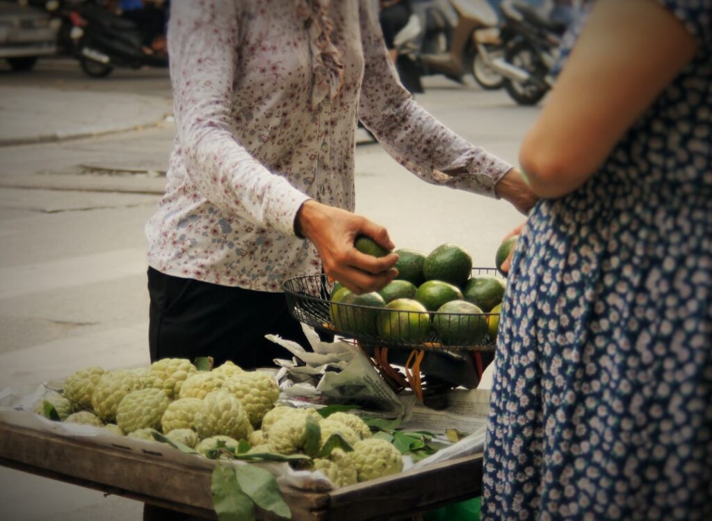 Local vendor handing produce to a customer