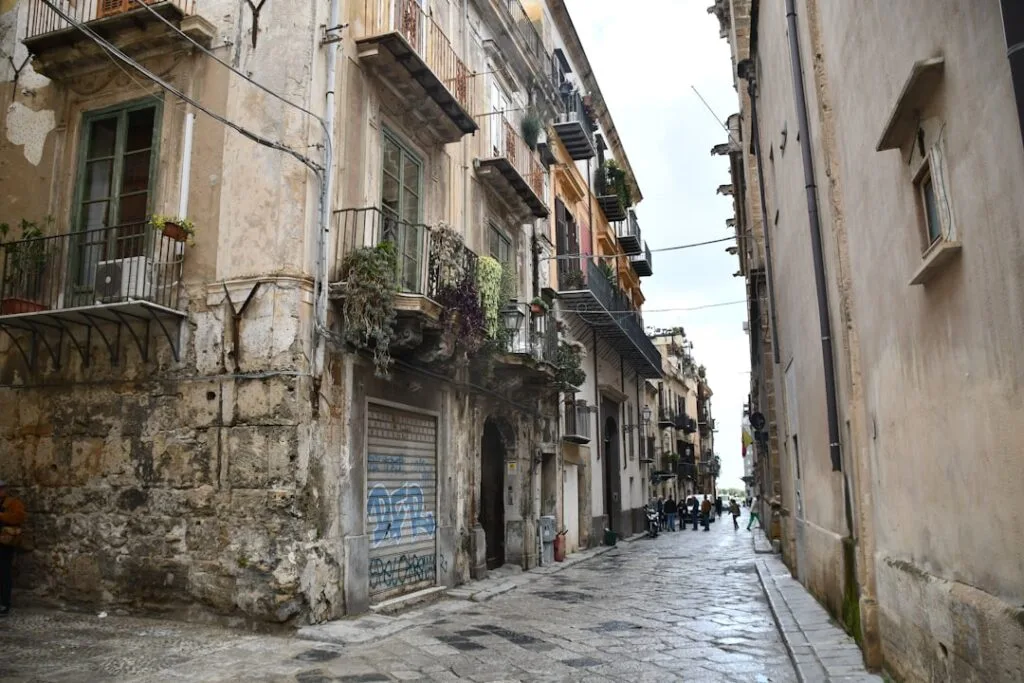 Rue pavée étroite de la Giudecca à Palermo bordée d'immeubles anciens