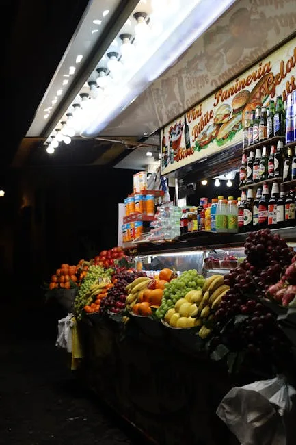 Étale de fruits colorés et boissons dans un kiosque nocturne à Palerme