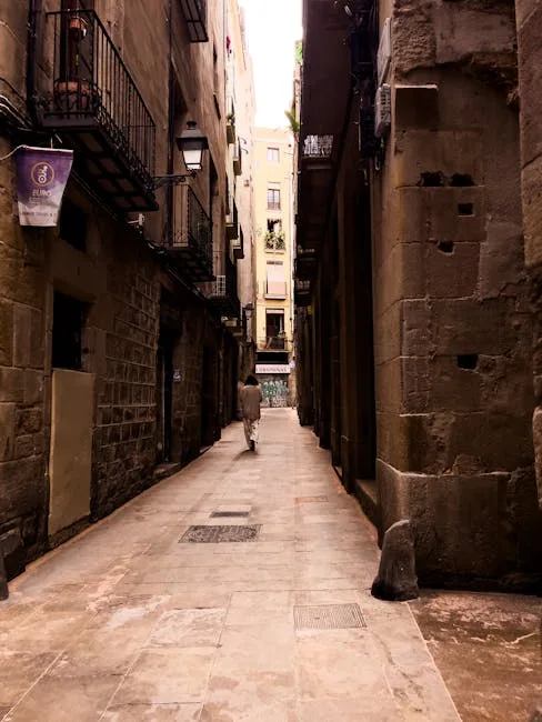 Ruelle étroite de la Giudecca à Palerme avec passante solitaire.