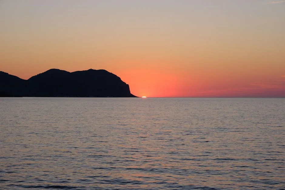 Coucher de soleil derrière le cap silhouetté au large de Palermo