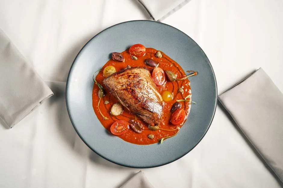 Filet poêlé sur sauce sicilienne, olives et tomates, restaurant à Palermo