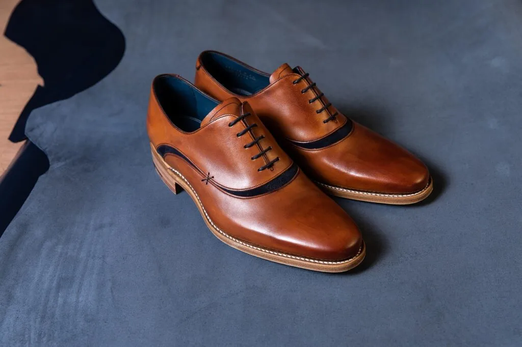 Paire de chaussures en cuir marron posée sur tissu, boutique Palermo