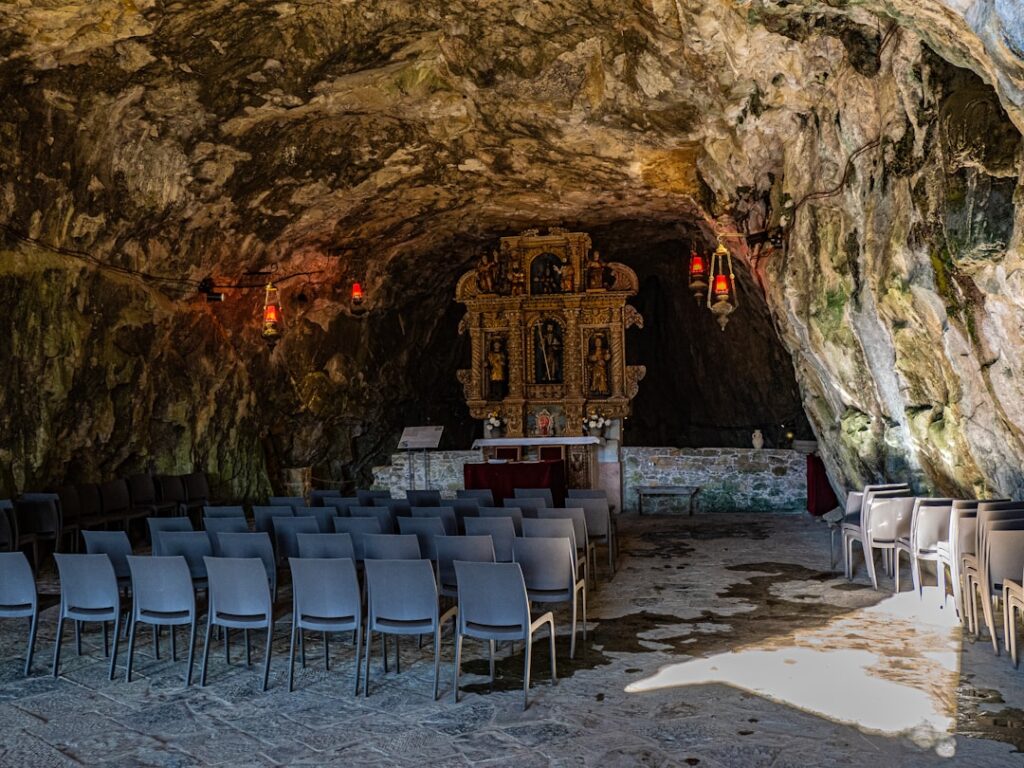 Höhlenkapelle in Matera mit Reihen von Stühlen und goldenem Altar