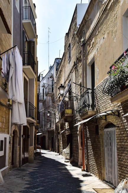 Enger sonniger Gassenabschnitt in Matera mit Wäsche an Balkonen