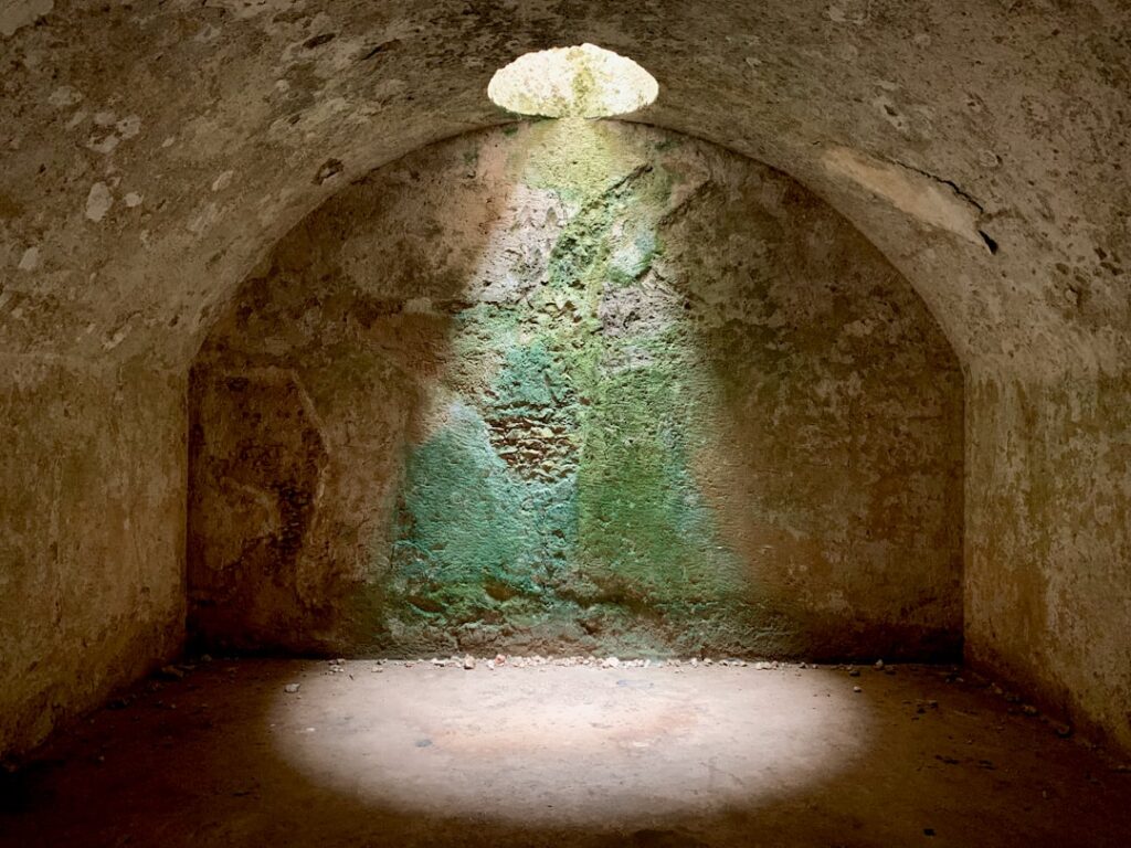 Lichtkegel fällt durch Öffnung in Höhlenraum der Sassi von Matera