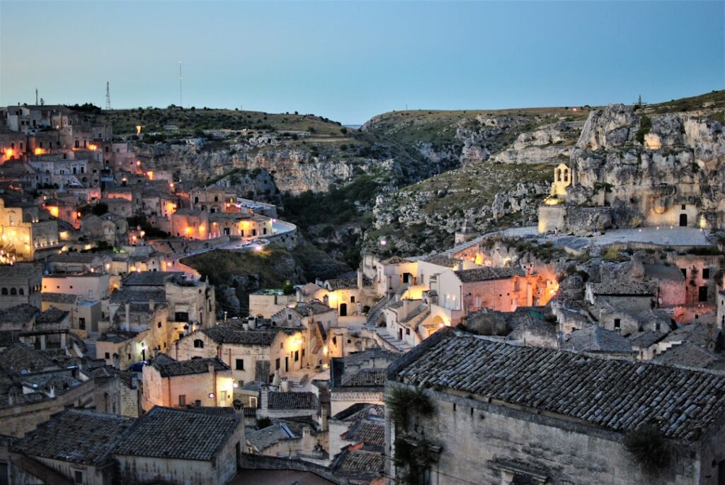 Abenddämmerung in Matera mit warmen Lichtern zwischen Höhlenhäusern