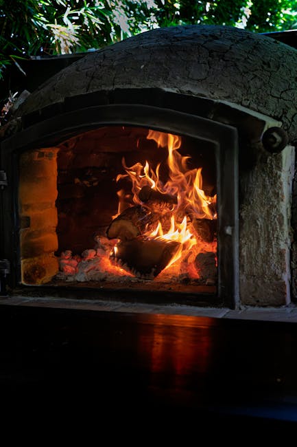 Brennender Holzofen mit flackerndem Feuer in traditionellem Backraum