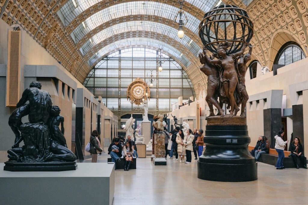 Große Museumshalle mit Skulpturen und prächtiger historischer Uhr