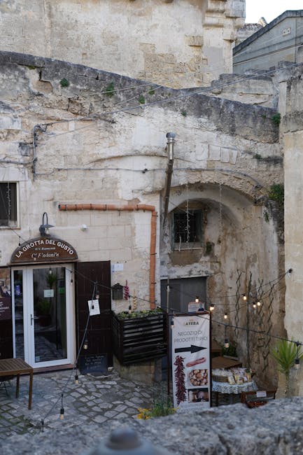 Kleiner Innenhof in Matera mit altem Steingebäude und Ladeneingang.