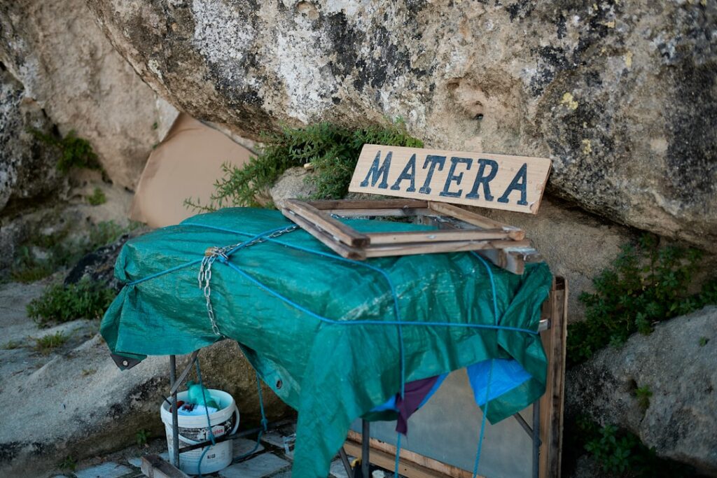 Provisorischer Stand mit Holzschild "MATERA" an einer Felswand
