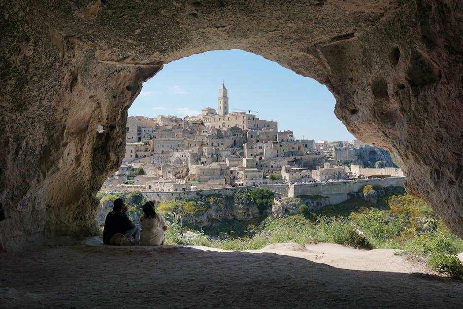 Matera-Blick durch Höhlenöffnung mit zwei sitzenden Personen im Vordergrund