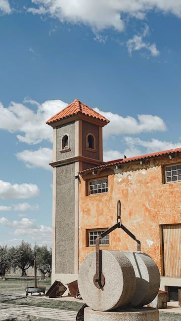 Großer runder Mühlstein vor einem orangefarbenen Gebäude nahe Matera