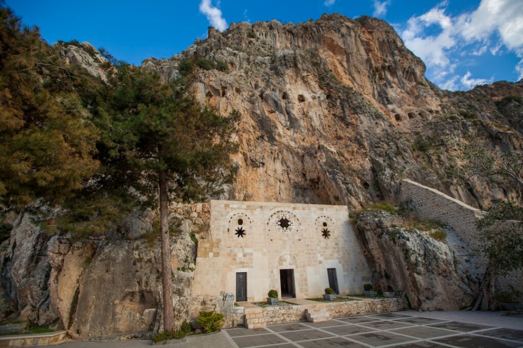 In den Felsen eingelassene weiße Kirchenfassade mit Bäumen in Matera