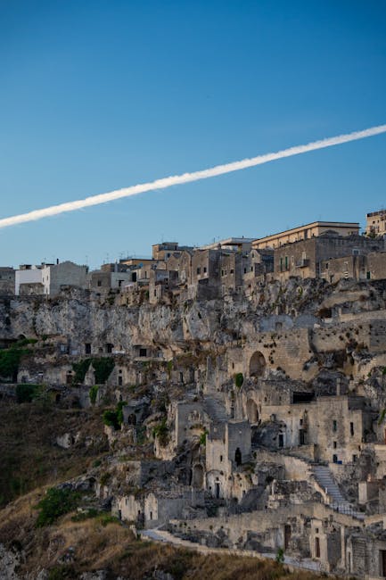 Terrassierte Sassi-Häuser von Matera unter klarem Himmel mit Kondensstreifen