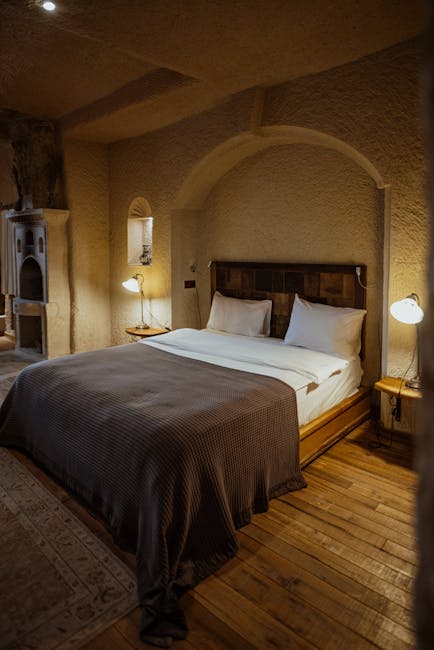 Gemütliches Höhlenzimmer mit Doppelbett und Holzfußboden in Matera