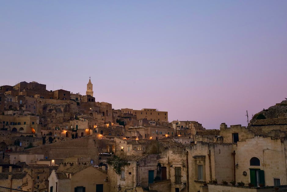 Matera bei Dämmerung mit Sassi-Häusern und beleuchtetem Kirchturm