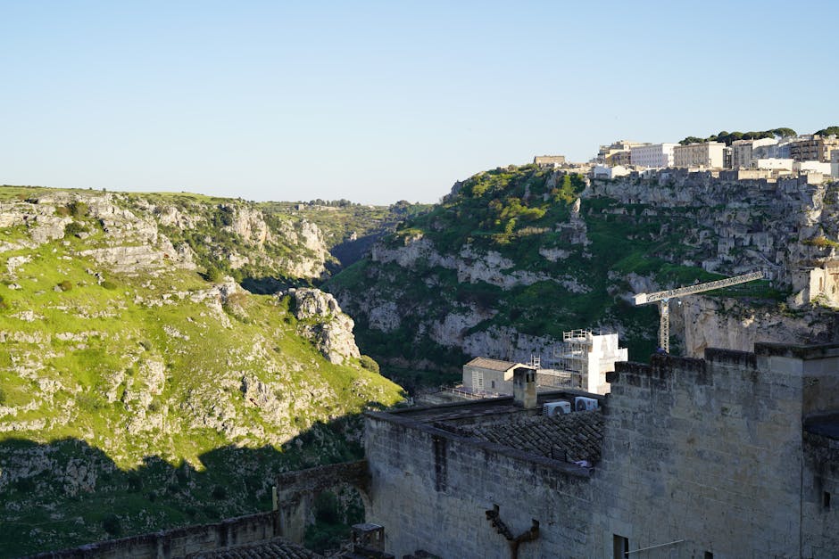 Tiefe grüne Schlucht neben den Sassi von Matera mit Baukran sichtbar