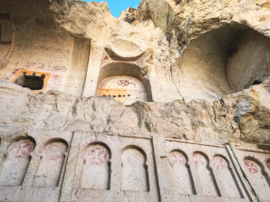 Felsnischen mit roten Ornamentmalereien in einer Höhlenkirche nahe Matera