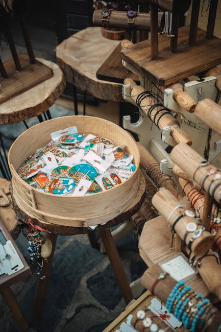 Handmade bracelets and pins arranged on wooden display table