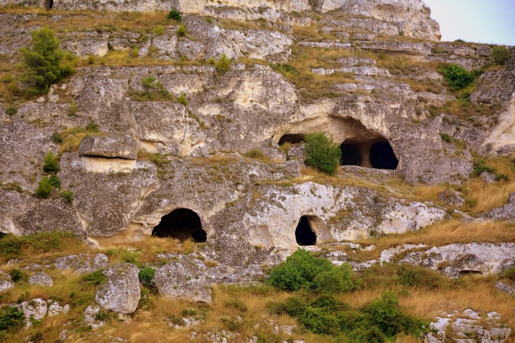 Ausgehöhlte Felsgrotten und Höhlenöffnungen an einem Hang bei Matera