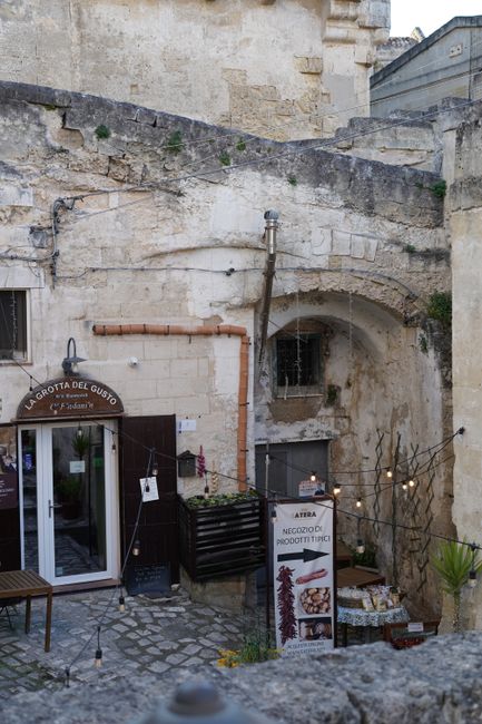 Wieczorna terasa Trattoria del Caveoso przy kamiennych fasadach Matery
