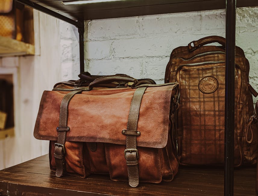 Brown leather satchel and backpack displayed on wooden shelf